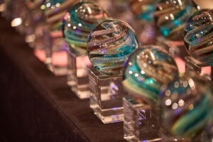 Crystal awards lined up on a table ready to be handed to winners.